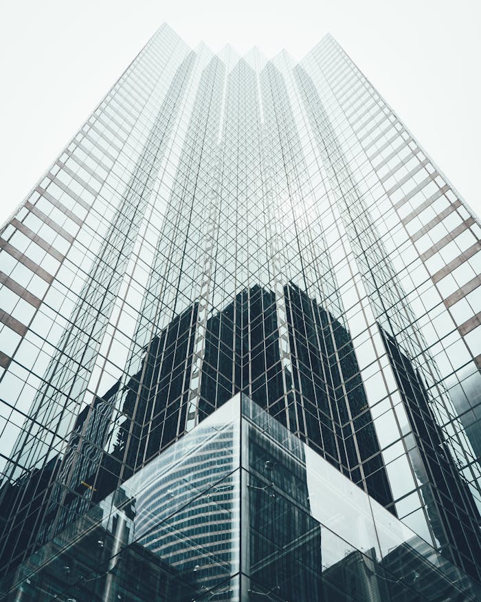 pexels-photo-1662159 Striking low angle view of a modern skyscraper with reflective glass facade in a cityscape.