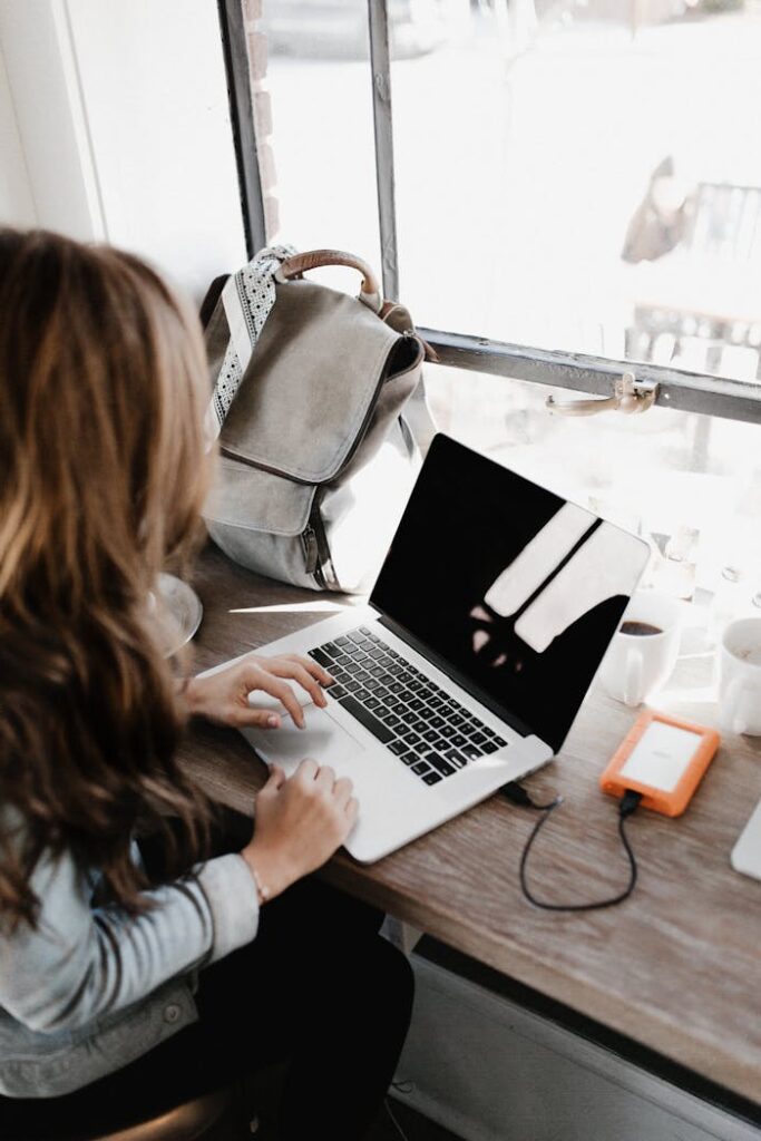 pexels-photo-3178818 Close-up Photography of Woman Sitting Beside Table While Using Macbook